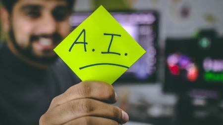 guy holding a post-it note with A.I. written on it